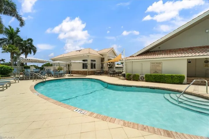 Community pool featuring a patio area and outdoor dining area