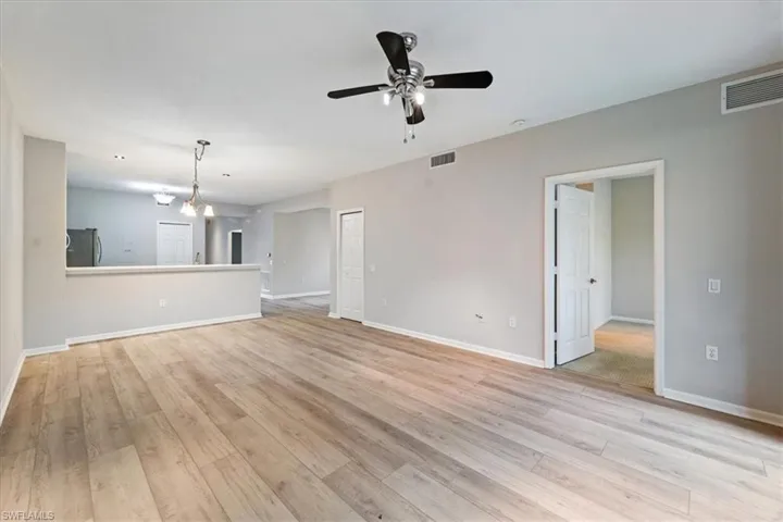 Unfurnished living room featuring a ceiling fan and light wood-type flooring