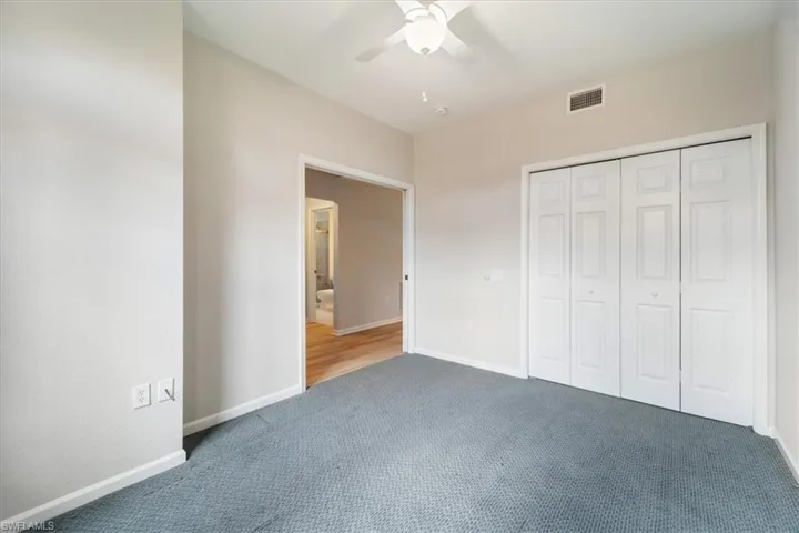 Unfurnished bedroom with carpet, a closet, and a ceiling fan