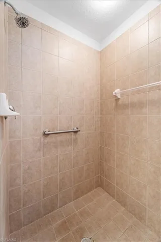 Bathroom with a tile shower and a textured ceiling