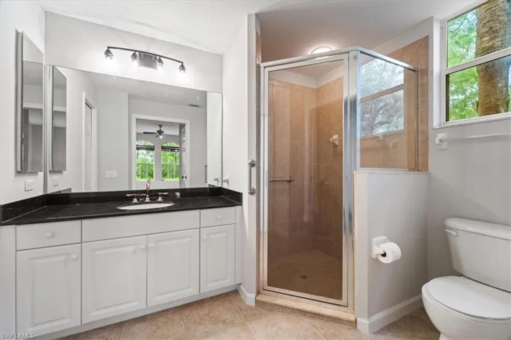 Full bathroom featuring vanity, a stall shower, and tile patterned floors