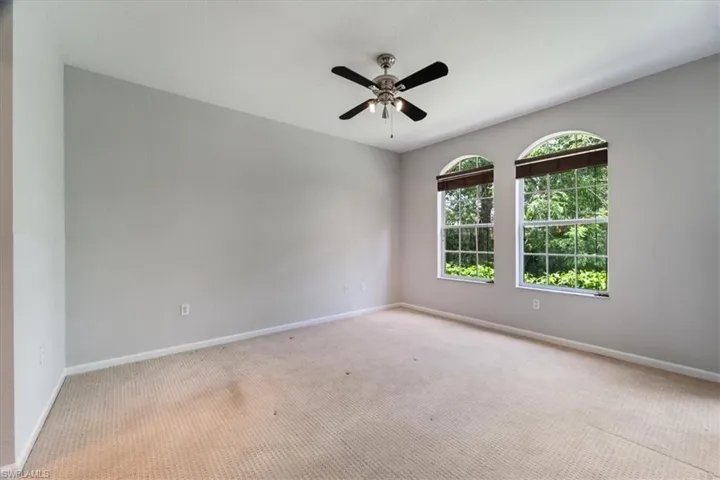 Carpeted empty room with baseboards and ceiling fan