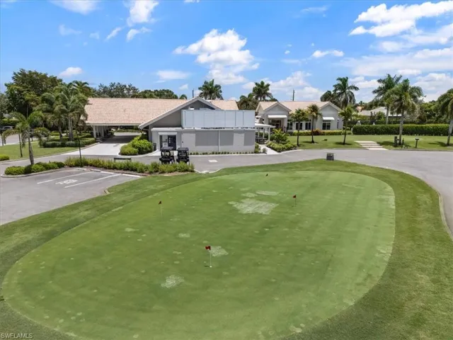 View of home's community with a putting green, uncovered parking, and golf course view