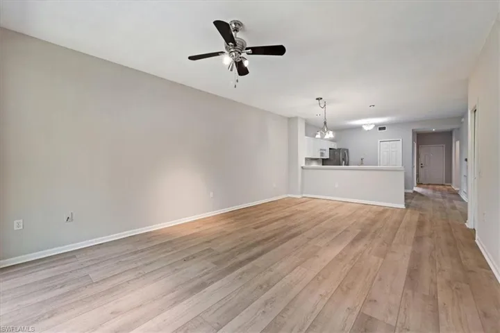 Unfurnished living room with a ceiling fan and light wood-style flooring