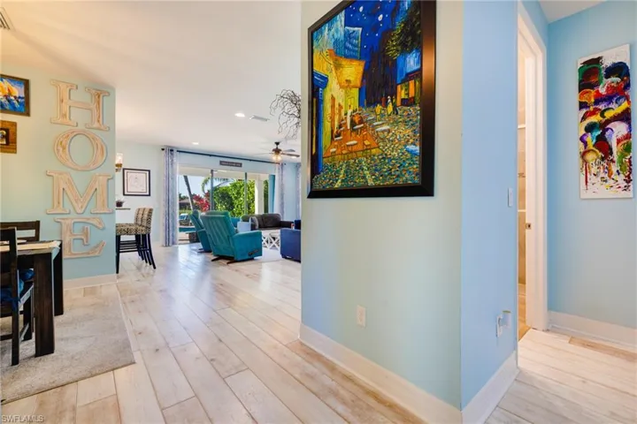Hall featuring baseboards, recessed lighting, wood finished floors, and visible vents