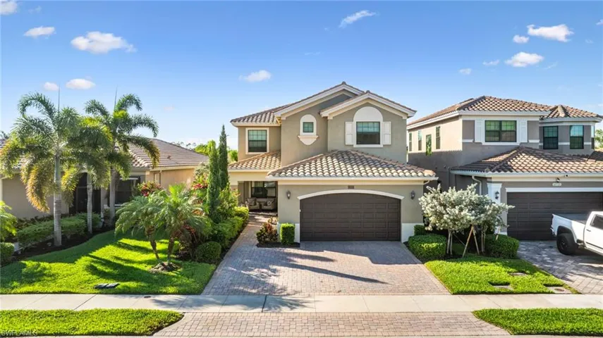 Mediterranean / spanish home featuring a garage, driveway, a tile roof, and stucco siding