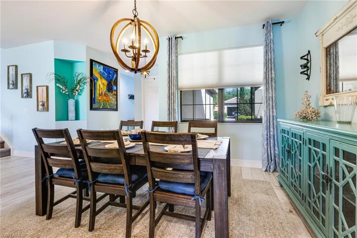 Dining area with a healthy amount of sunlight, wood finished floors, and a chandelier
