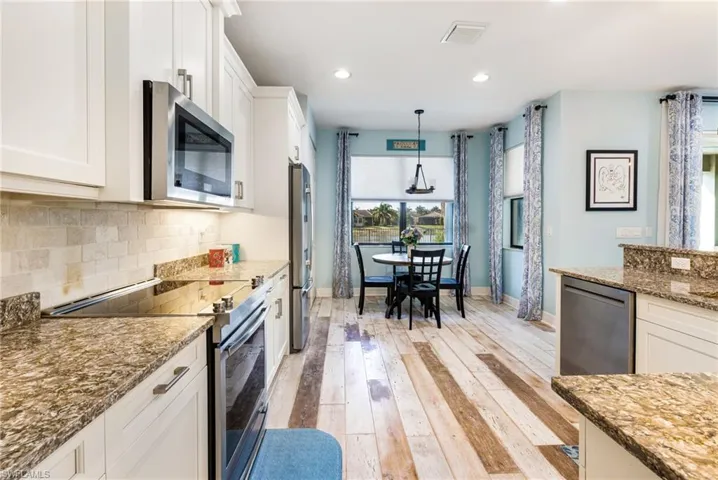 Kitchen with visible vents, tasteful backsplash, baseboards, white cabinets, and stainless steel appliances