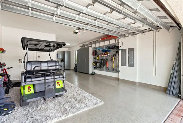Epoxy-coated 3 car tandem garage with built-in wall organization, overhead garage door opener, and steel storage cabinets