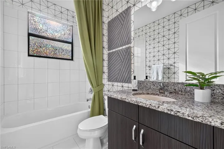 3rd bathroom. Integrated tub and shower with white tile surround