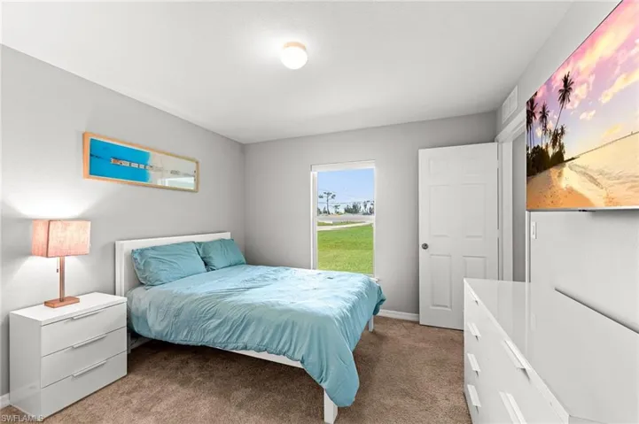 Bedroom featuring light colored carpet and baseboards