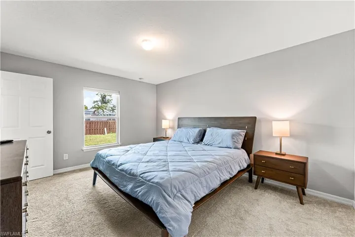 Bedroom with light carpet and baseboards