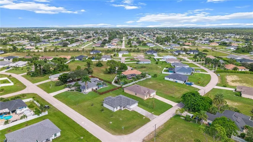 Aerial view of property and surrounding area featuring nearby suburban area