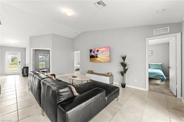 Living room featuring lofted ceiling and light tile patterned floors