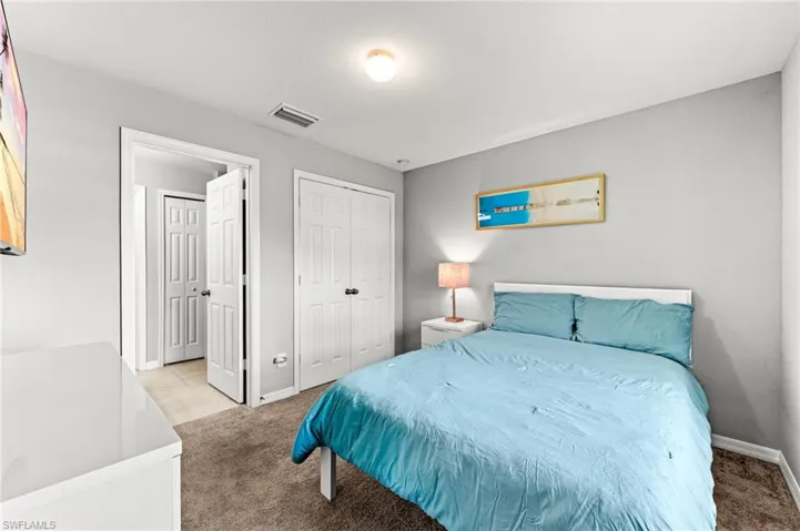 Bedroom featuring light carpet and a closet