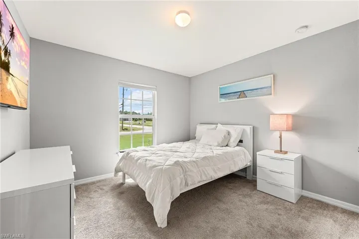 Bedroom featuring light colored carpet