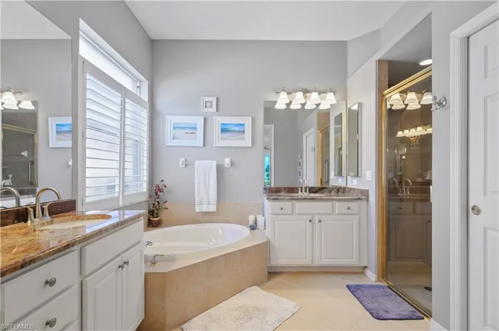 Bathroom with tile patterned floors, a sink, a garden tub, and a shower stall