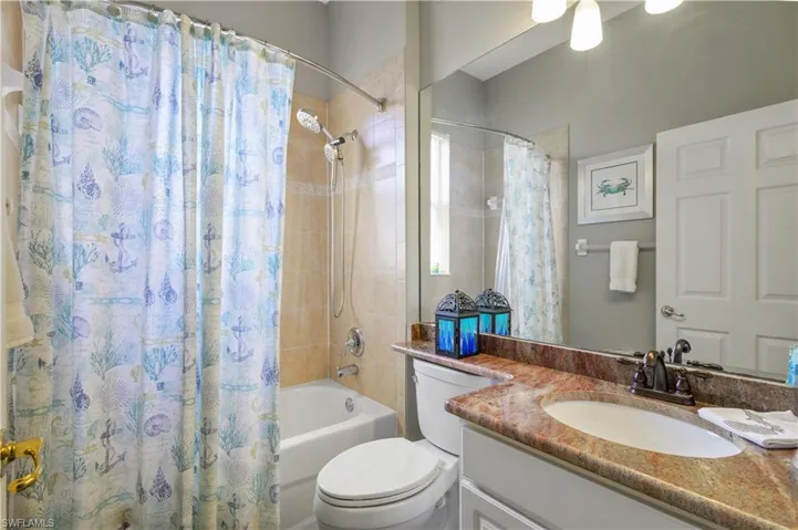 Bathroom featuring toilet, vanity, and shower / bath combination with curtain