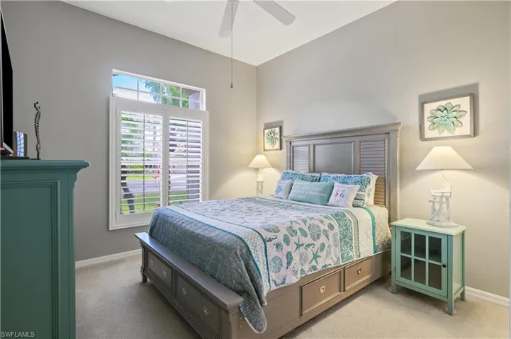 Bedroom featuring light carpet, baseboards, and ceiling fan