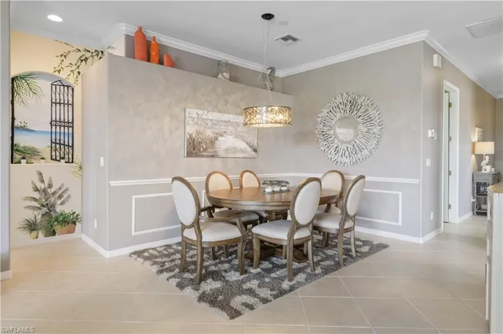Tiled dining space featuring baseboards, ornamental molding, and visible vents