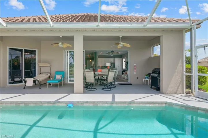 Outdoor pool featuring a patio, a grill, and glass enclosure