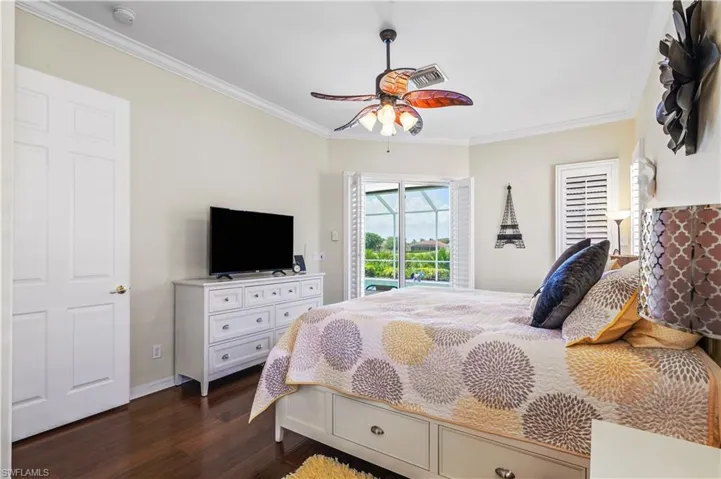 Bedroom with dark wood-style flooring, baseboards, ornamental molding, a ceiling fan, and access to exterior