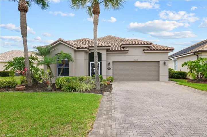 Mediterranean / spanish-style home with an attached garage, a tile roof, stucco siding, and decorative driveway