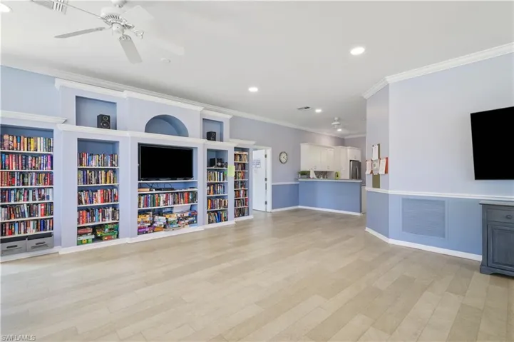 Unfurnished living room featuring visible vents, ornamental molding, light wood-type flooring, and a ceiling fan