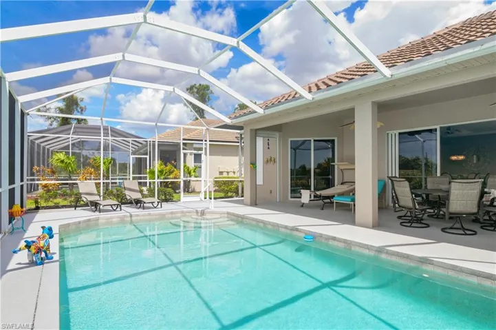 Outdoor pool featuring glass enclosure and a patio area