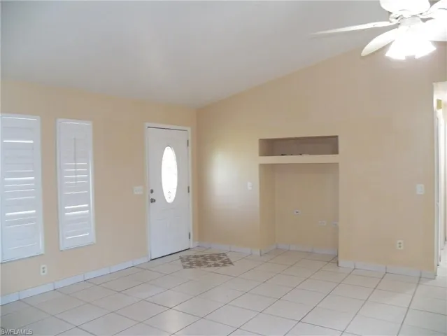 Living room featuring tile floor medallion, lofted ceiling, tile floor