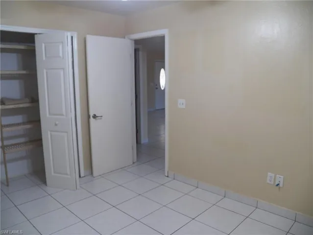 Second bedroom with built in shelving in the closet