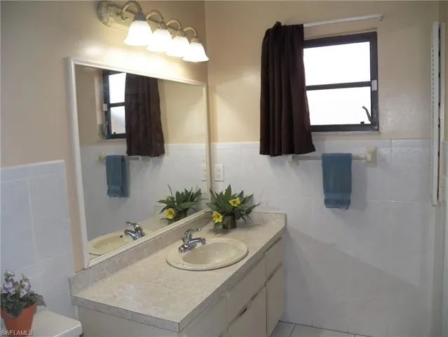 Primary bath with window and vanity, tiled walls
