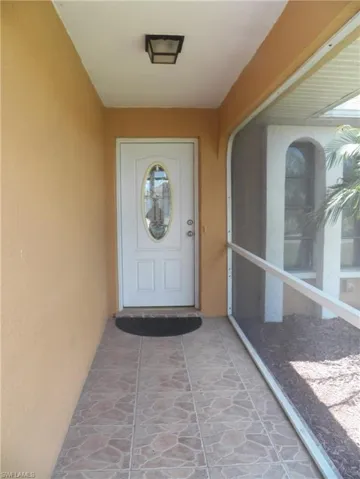Screened entry featuring tile flooring and front door with glass insert