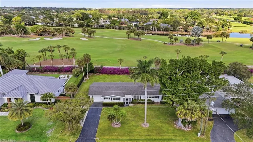 Aerial view of a golf course and a nearby body of water