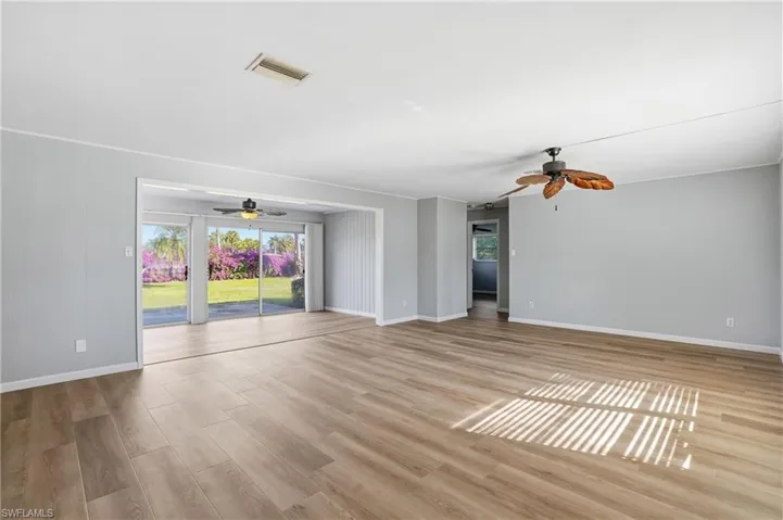 Unfurnished living room with light wood finished floors and ceiling fan