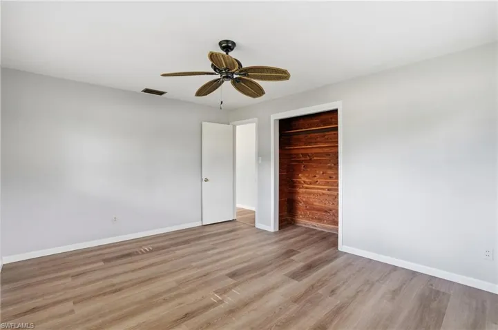 Unfurnished bedroom featuring wood finished floors, a ceiling fan, and a closet