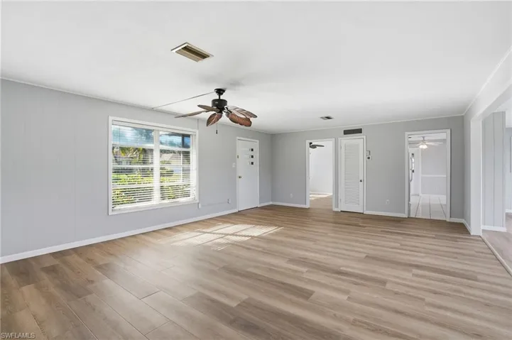 Unfurnished living room featuring light wood-style flooring and ceiling fan