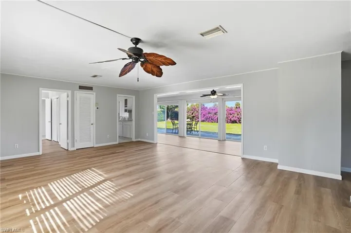 Unfurnished living room with light wood finished floors and crown molding