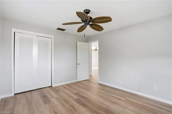 Unfurnished bedroom featuring ceiling fan, light wood-style flooring, and a closet