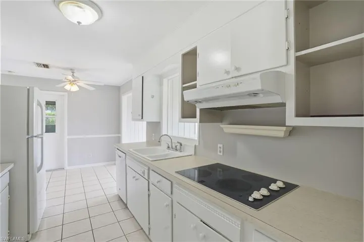 Kitchen featuring white cabinetry, white appliances, light countertops, and light tile patterned flooring