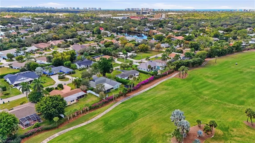 Aerial perspective of suburban area with a golf course and city skyline