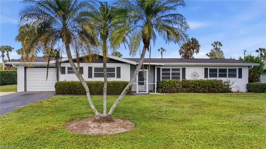 Ranch-style house featuring stucco siding and a front lawn