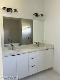 Bathroom with double vanity and baseboards