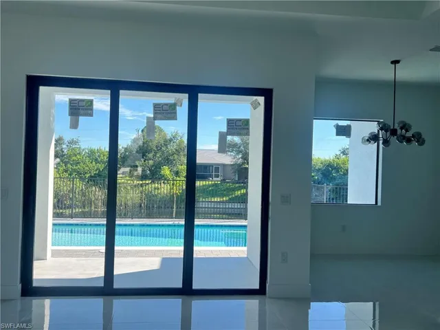 Doorway to outside featuring tile patterned flooring and a chandelier