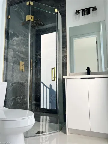 Full bathroom with a marble finish shower and vanity