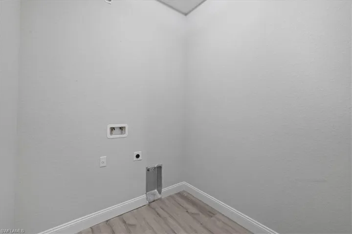 Laundry area featuring light wood-style floors, hookup for an electric dryer, and washer hookup