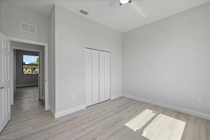Unfurnished bedroom featuring light wood finished floors, ceiling fan, and a closet