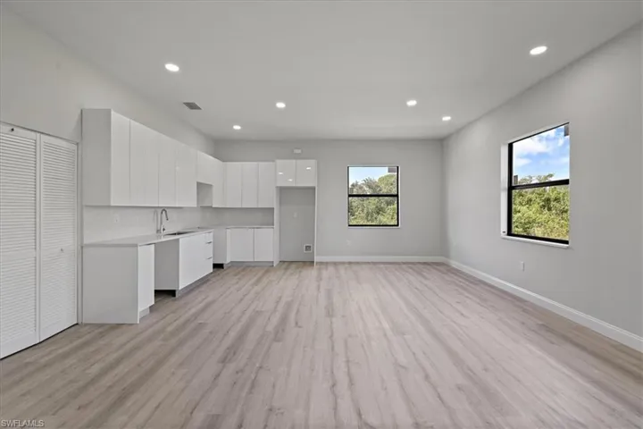 Unfurnished living room featuring light wood finished floors, recessed lighting, and plenty of natural light