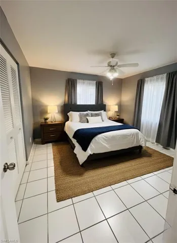 Bedroom featuring light tile patterned floors, a closet, and ceiling fan