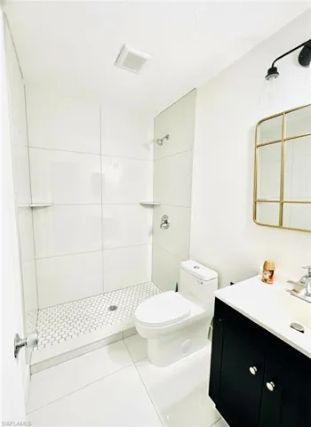 Bathroom with a stall shower, vanity, and light tile patterned floors